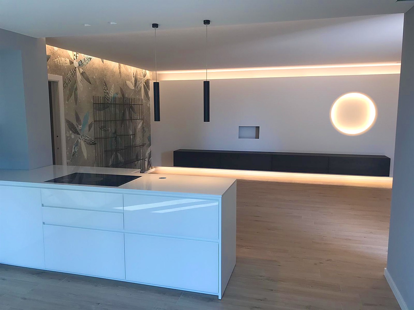 Cucina e soggiorno con controsoffitto, gola luminosa e luce circolare a parete