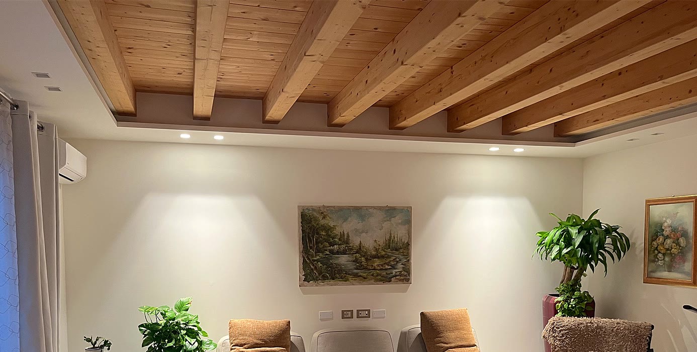 Wohnzimmer mit Holzbalken, beleuchtet von Spots